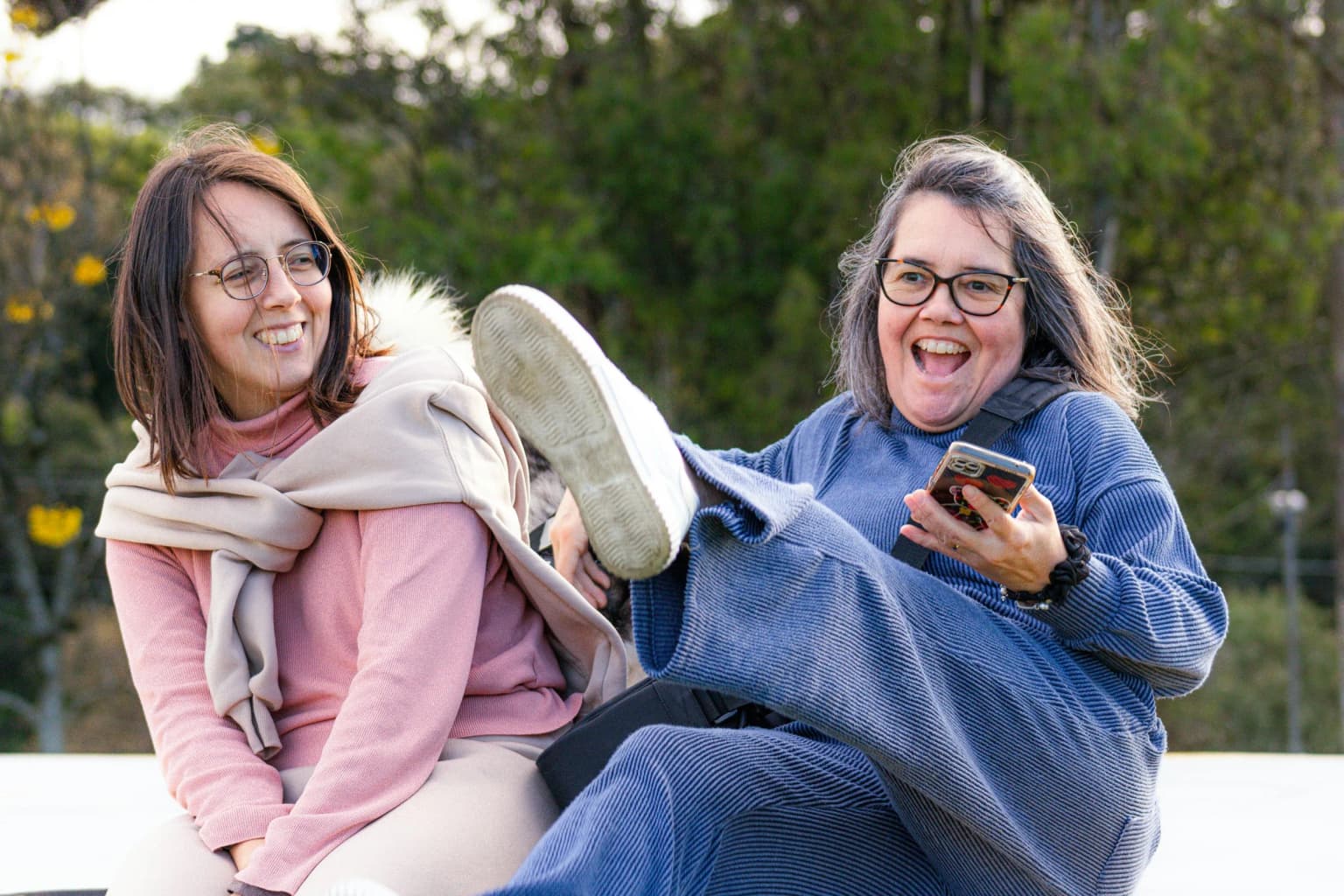 Amigas riendo juntas al aire libre.