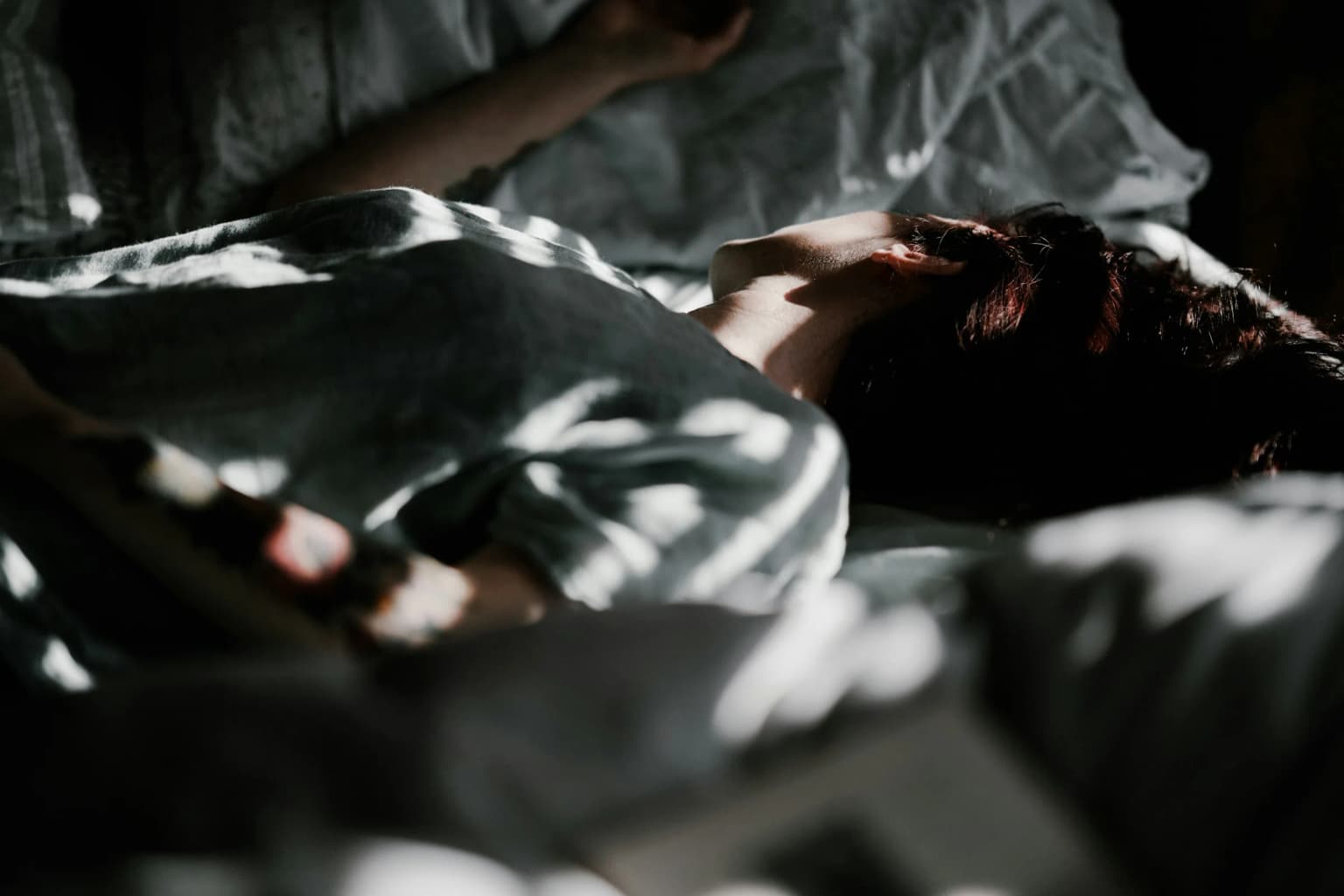 Mujer despierta en la cama de madrugada.