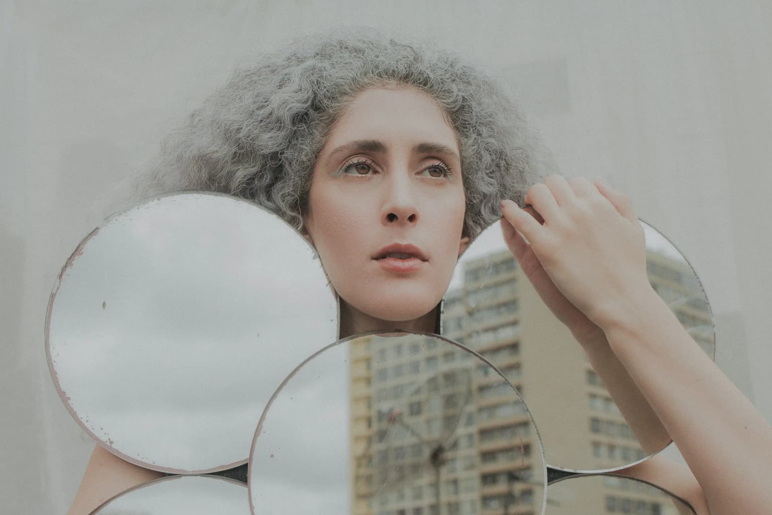 Mujer mirándose el cabello frente al espejo.